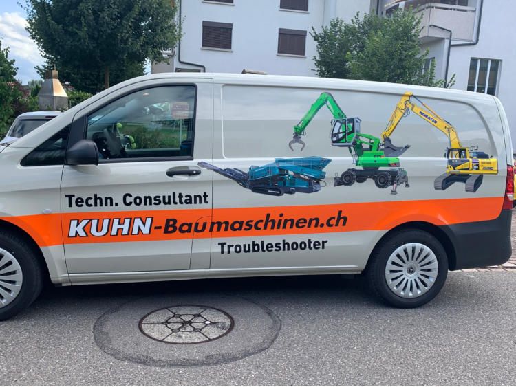 Weisser Lieferwagen von Kuhn Baumaschinen mit Baggern und orangem Streifen