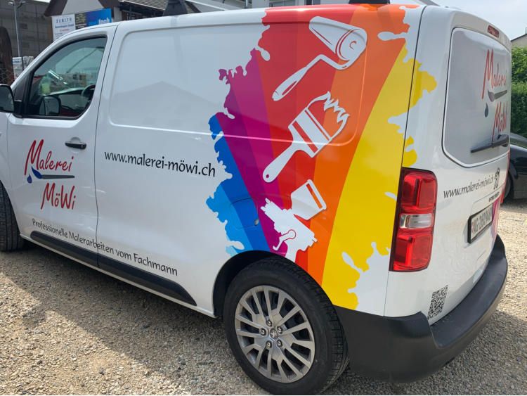 Weisser Lieferwagen der Malerei MöWi mit bunten Farbklecksen und Pinsel